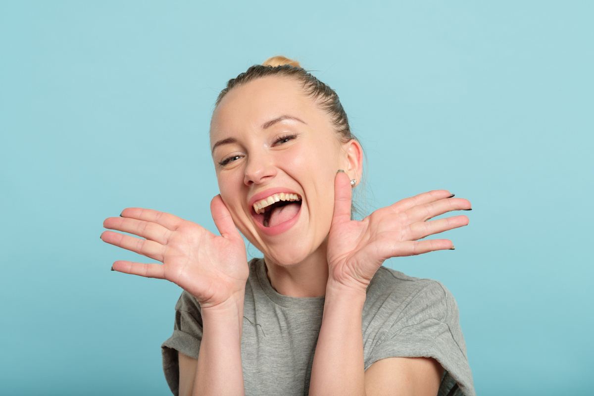 joyful thrilled woman beaming smile hands emotion